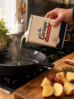 Pouring Original tallow cooking oil from the tin into a hot cast iron skillet